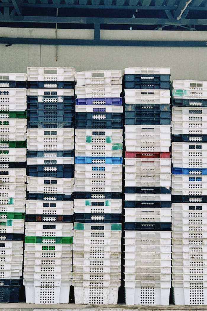 Organized stacks of colorful plastic crates in a warehouse in Konaev, Kazakhstan.